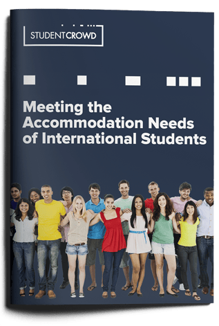 Front cover of the StudentCrowd report titled 'Meeting the Accommodation Needs of International Students.' Below the title, a photo shows a diverse group of people standing together arm-in-arm.